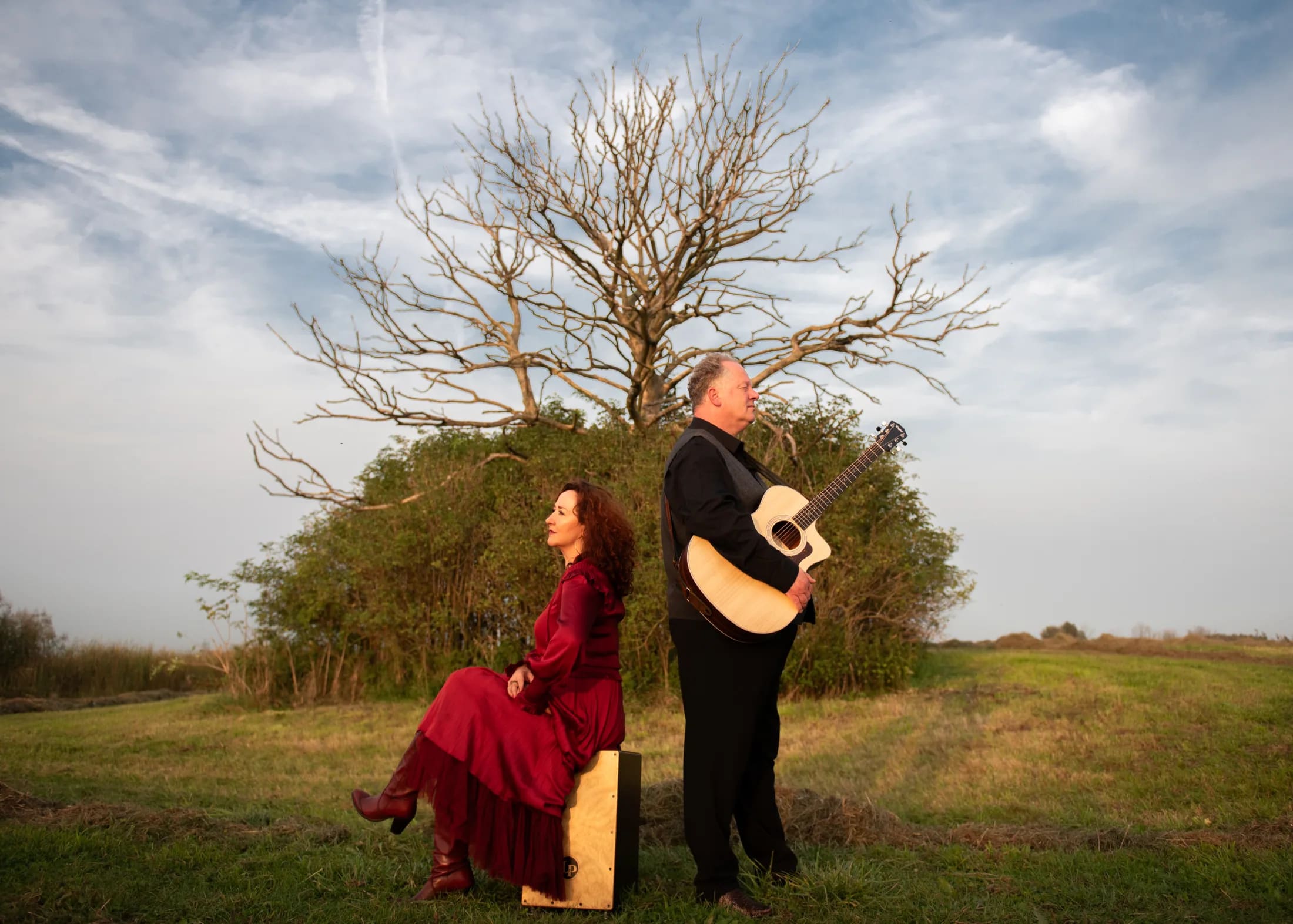 Arthur en Bettina in open veld bij een boom, met gitaar en warme avondlucht